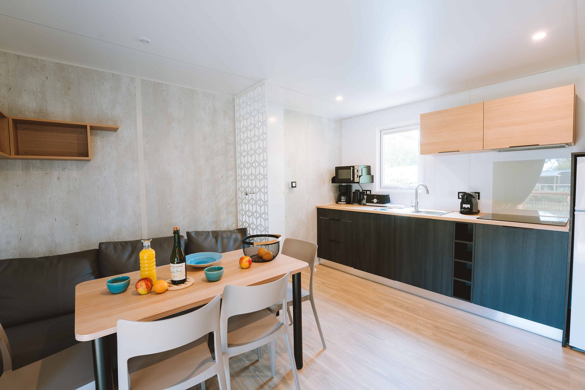 Le séjour et la cuisine équipée d’un cottage Premium 6 personnes du camping Portland
