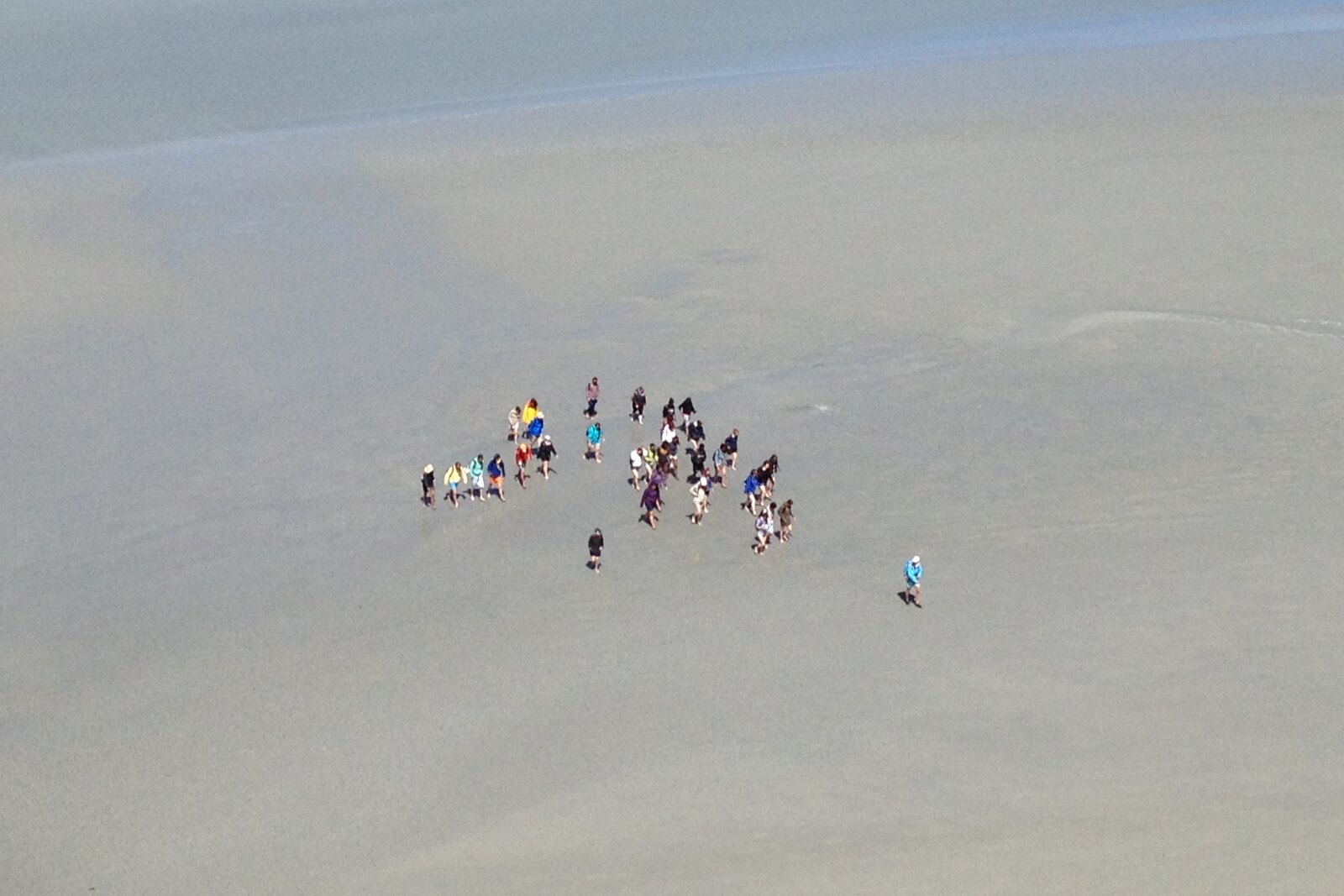 Een groep steekt de baai van de Mont-Saint-Michel te voet over met een gids