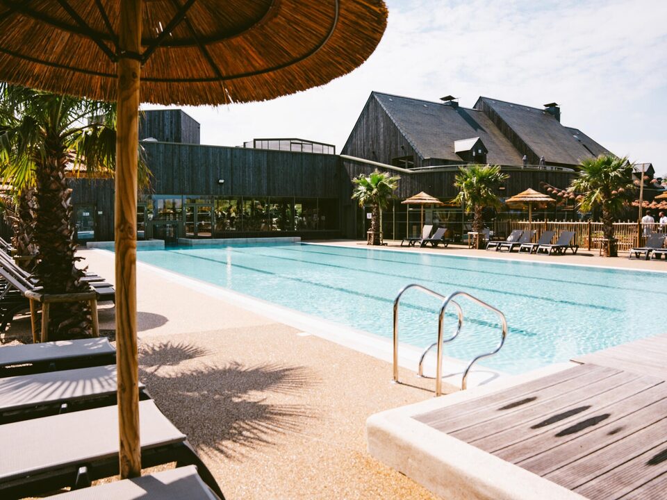 Strooien parasols en ligweides buiten, waterpark van Camping Portland